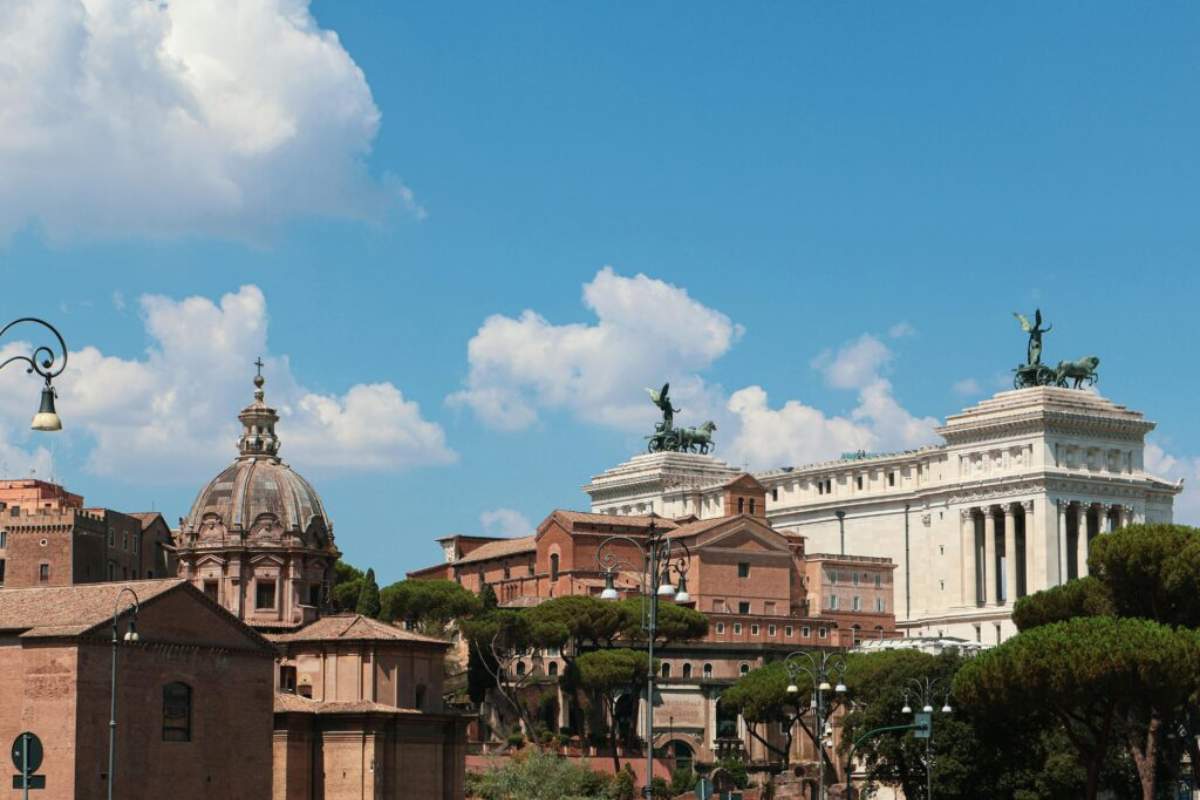 Sunny view of historic Roman architecture and umbrella pine trees