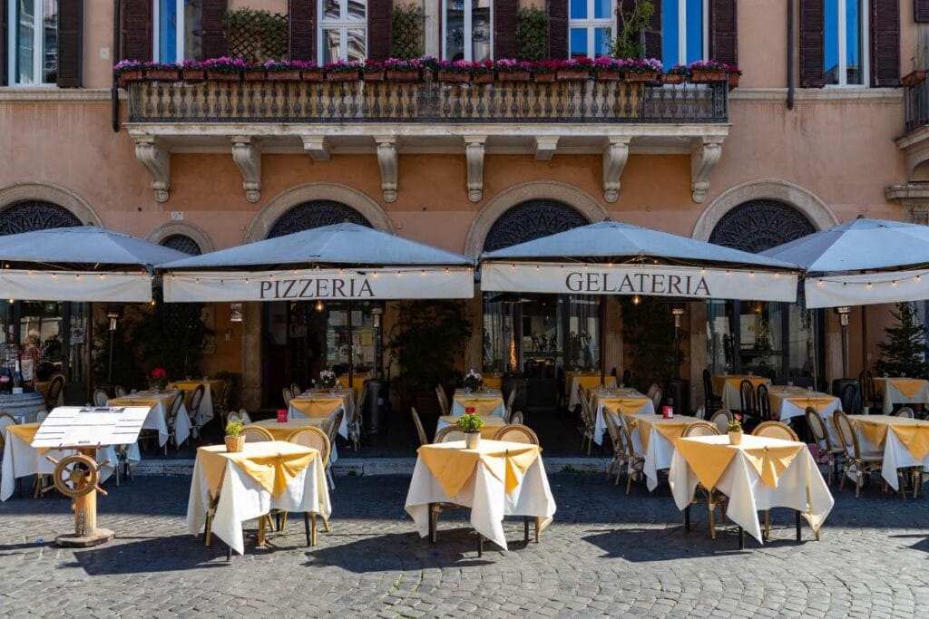 Outdoor seating at a traditional Roman pizzeria and gelateria suitable for family dining