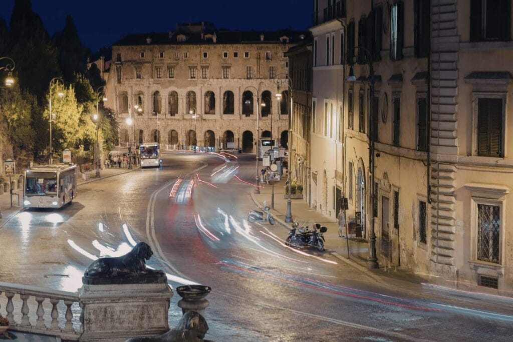 Public buses driving through Rome city center at night